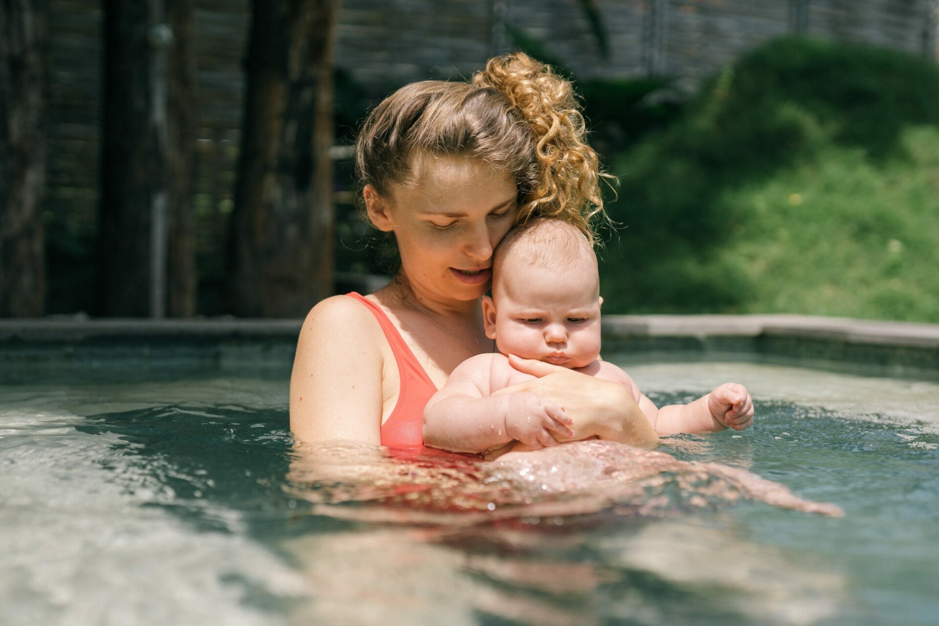 Un bébé en séance d'aquathérapie dans une piscine adaptée.
