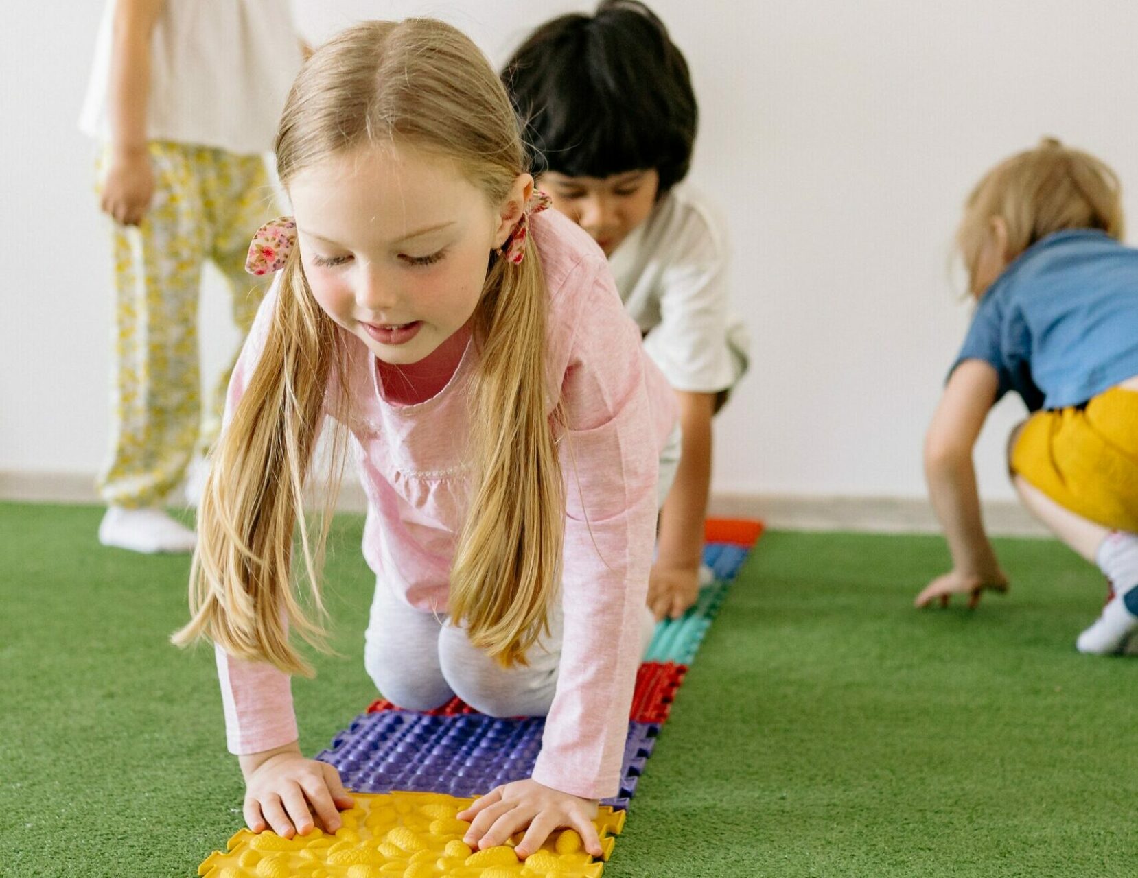 thérapie intensive - séance de psychomotricité pour les enfants atteints de troubles du développement ou de paralysie cérébrale. les enfants se déplacent à quatre pattes sur les tapis sensoriels.